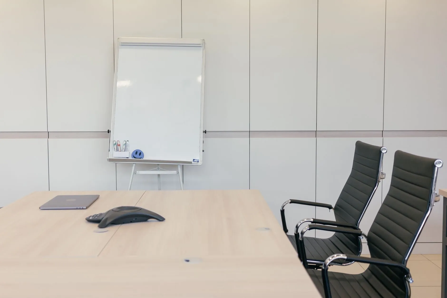 The meeting room at the practice, with a table, two chairs and a flip chart