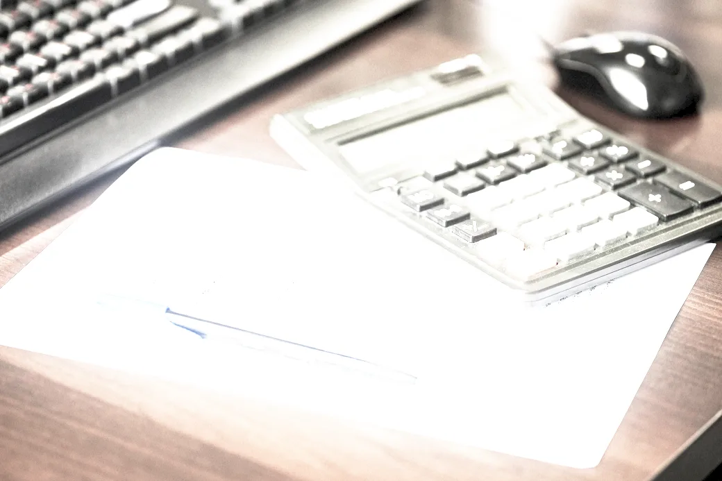 Two accountants reviewing printed accounts at a table under even, low-contrast light